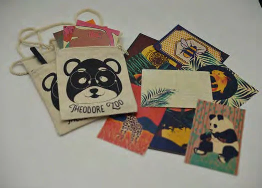 Theodore Zoo raccoon mark screen-printed on a cotton drawstring pouch with its postcard set